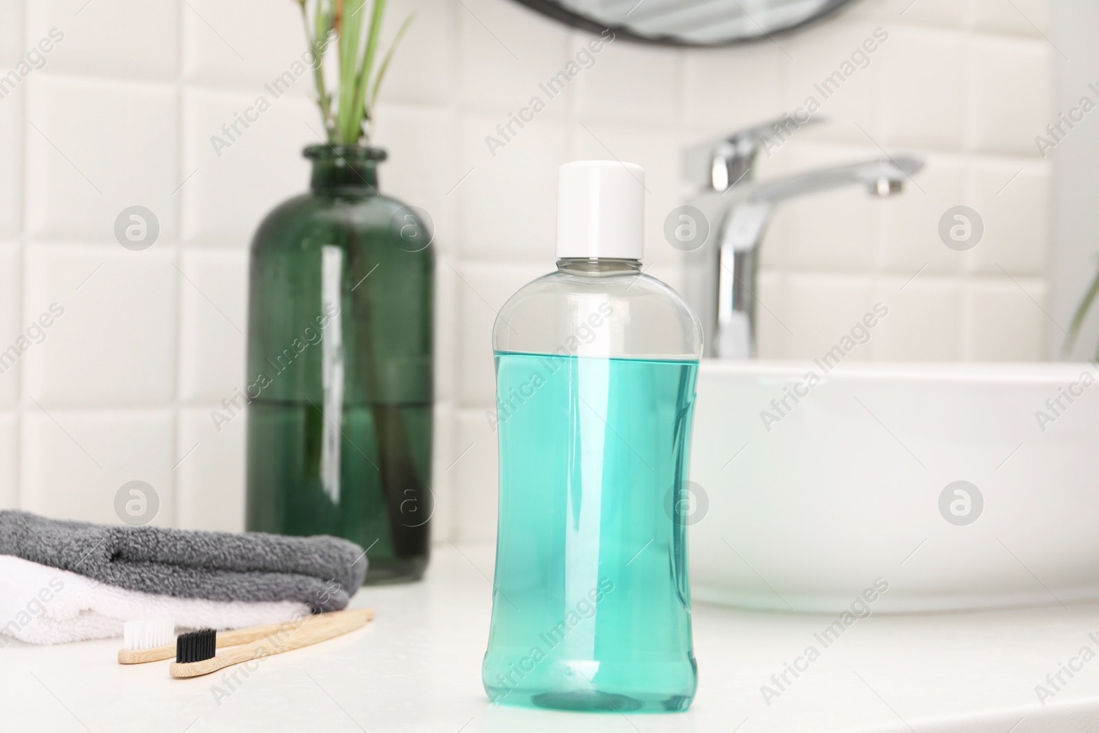 Photo of Bottle of mouthwash on white table in bathroom