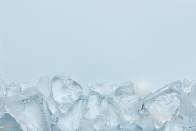 Photo of Pieces of crushed ice on light blue background, top view. Space for text