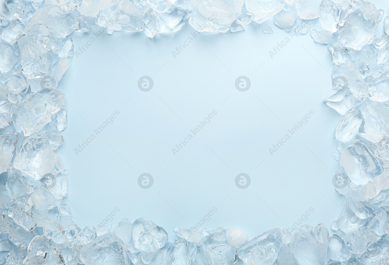 Photo of Frame of crushed ice on light blue background, top view. Space for text