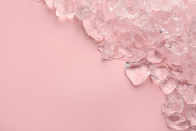 Pieces of crushed ice on pink background, top view. Space for text