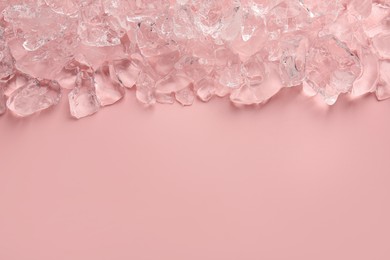 Photo of Pieces of crushed ice on pink background, top view. Space for text