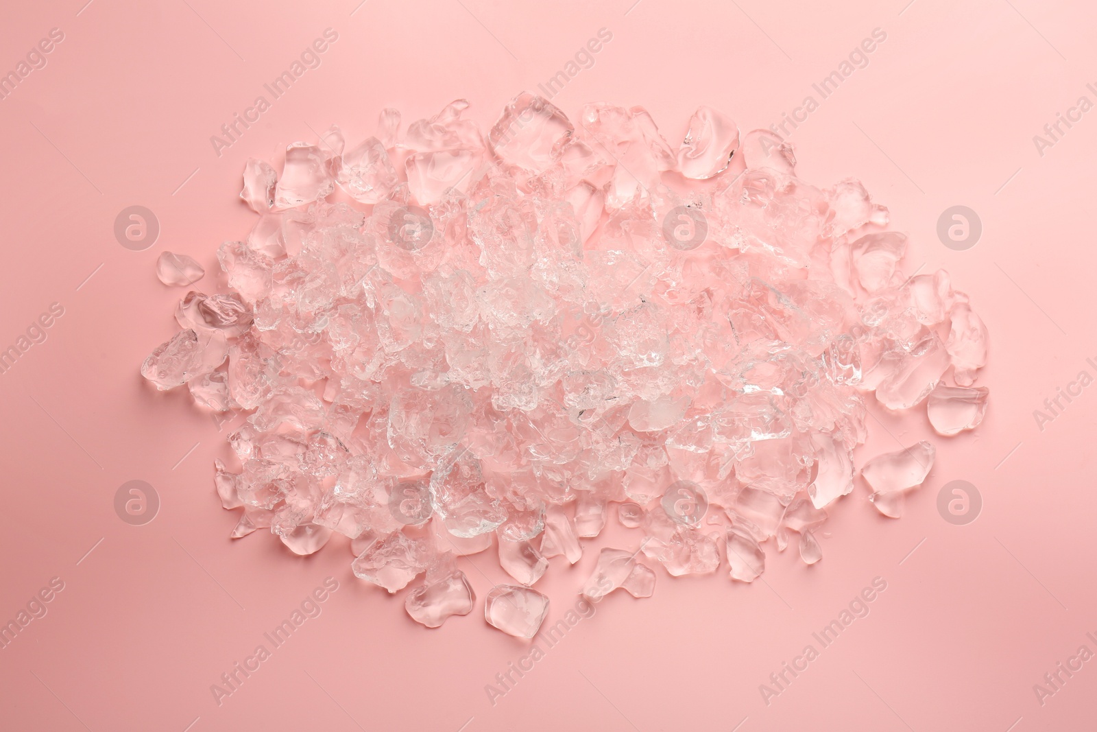 Photo of Pieces of crushed ice on pink background, top view