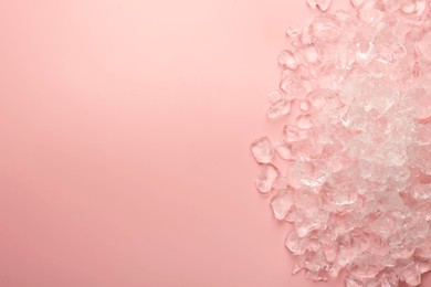 Pieces of crushed ice on pink background, top view. Space for text