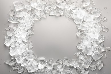 Frame of crushed ice on grey background, top view. Space for text