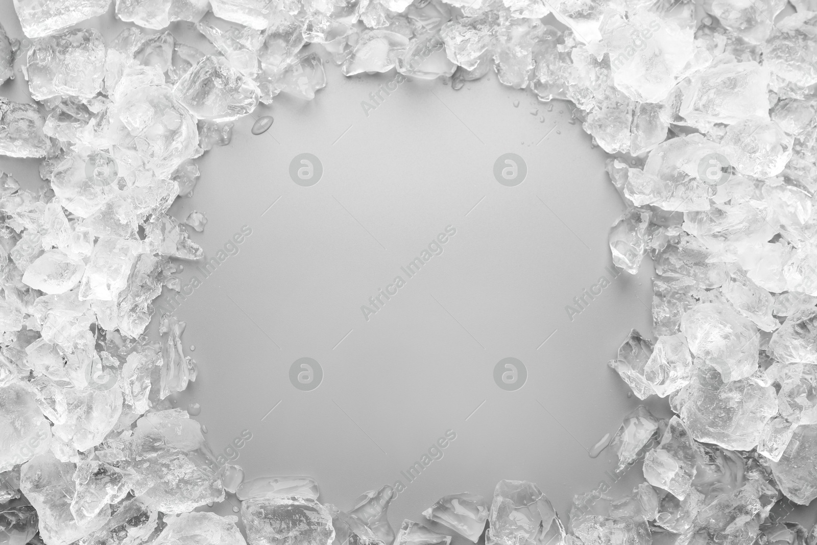 Photo of Frame of crushed ice on grey background, top view. Space for text