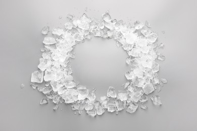 Photo of Frame of crushed ice on grey background, top view. Space for text