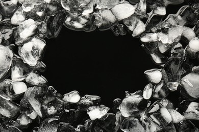 Frame of crushed ice on black background, above view. Space for text