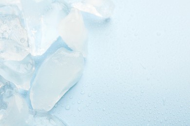Photo of Pieces of crushed ice on light blue background