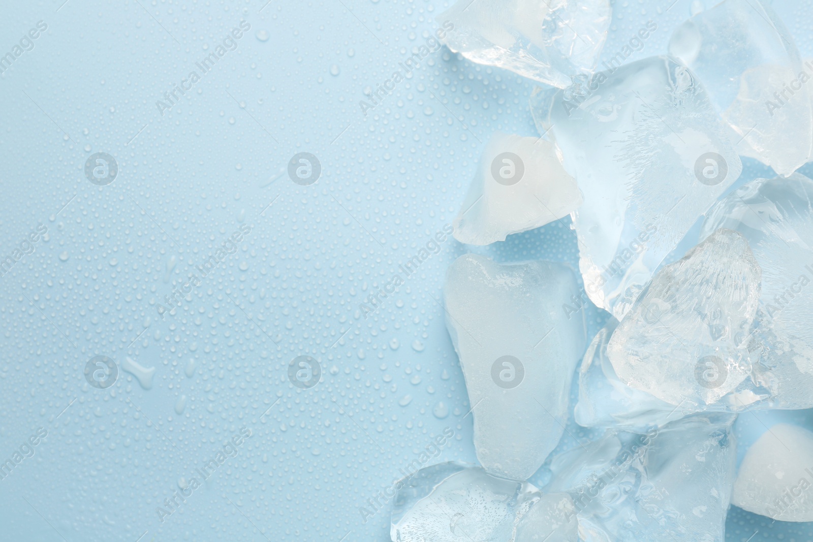 Photo of Pieces of crushed ice on light blue background