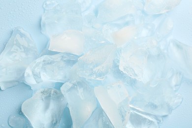 Photo of Pieces of crushed ice on light blue background