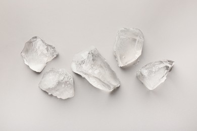 Pieces of crushed ice on grey background, top view