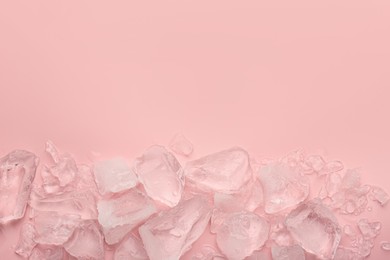 Pieces of crushed ice on pink background, top view. Space for text