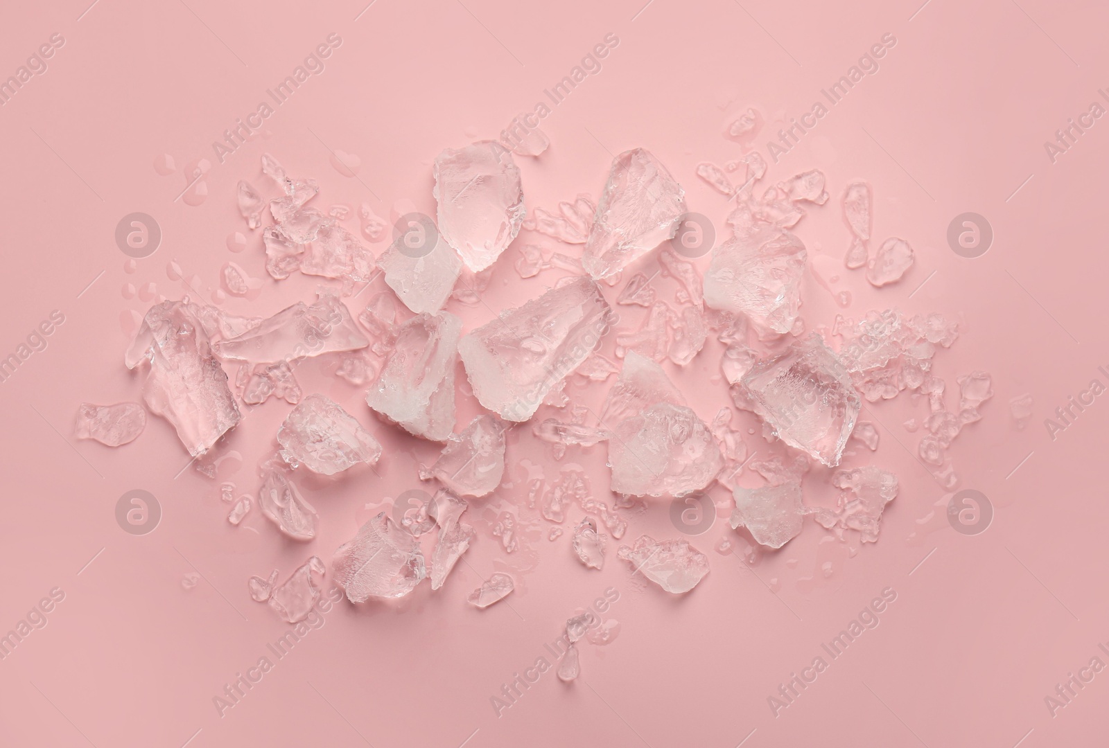 Photo of Pieces of crushed ice on pink background, top view