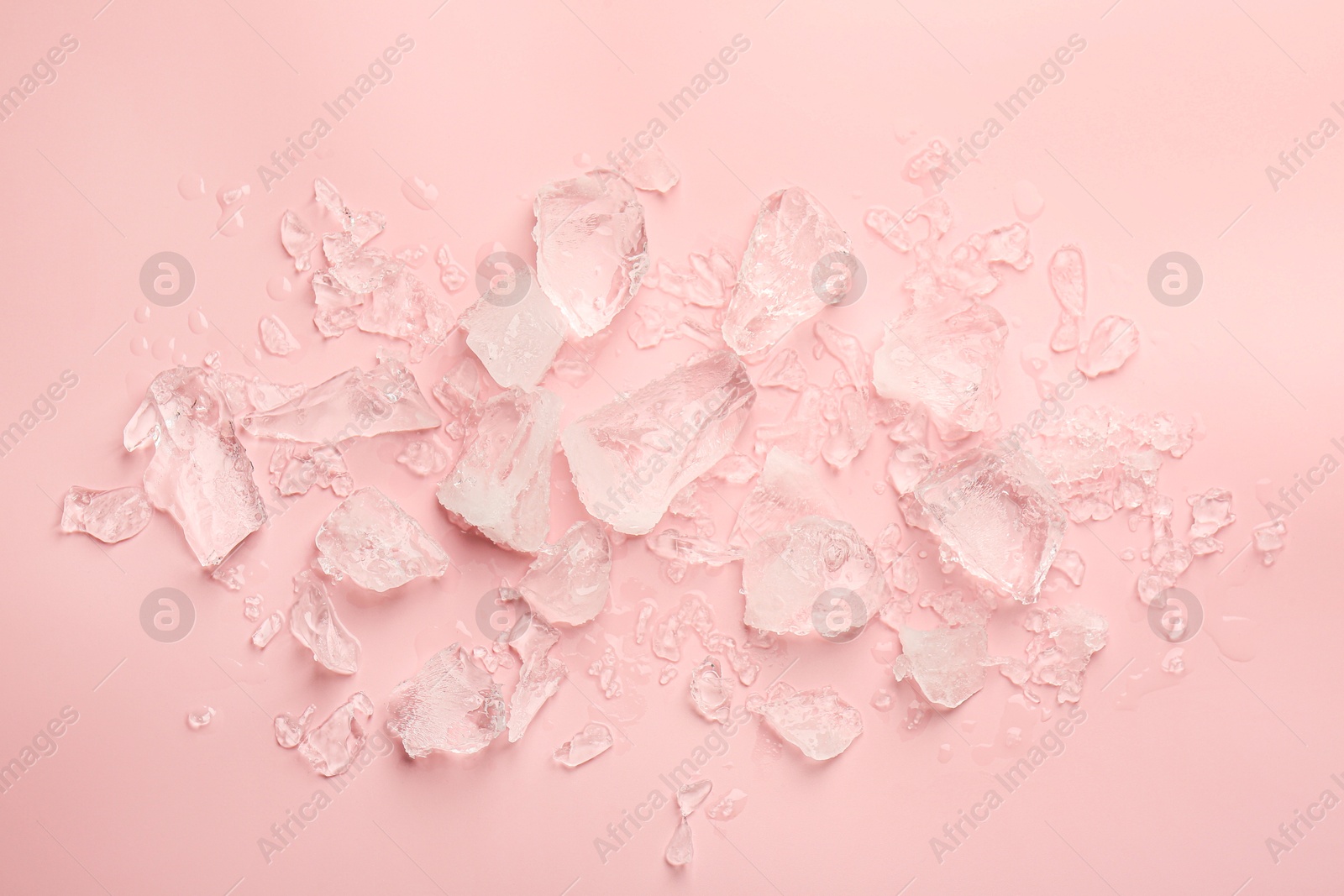 Photo of Pieces of crushed ice on pink background, top view