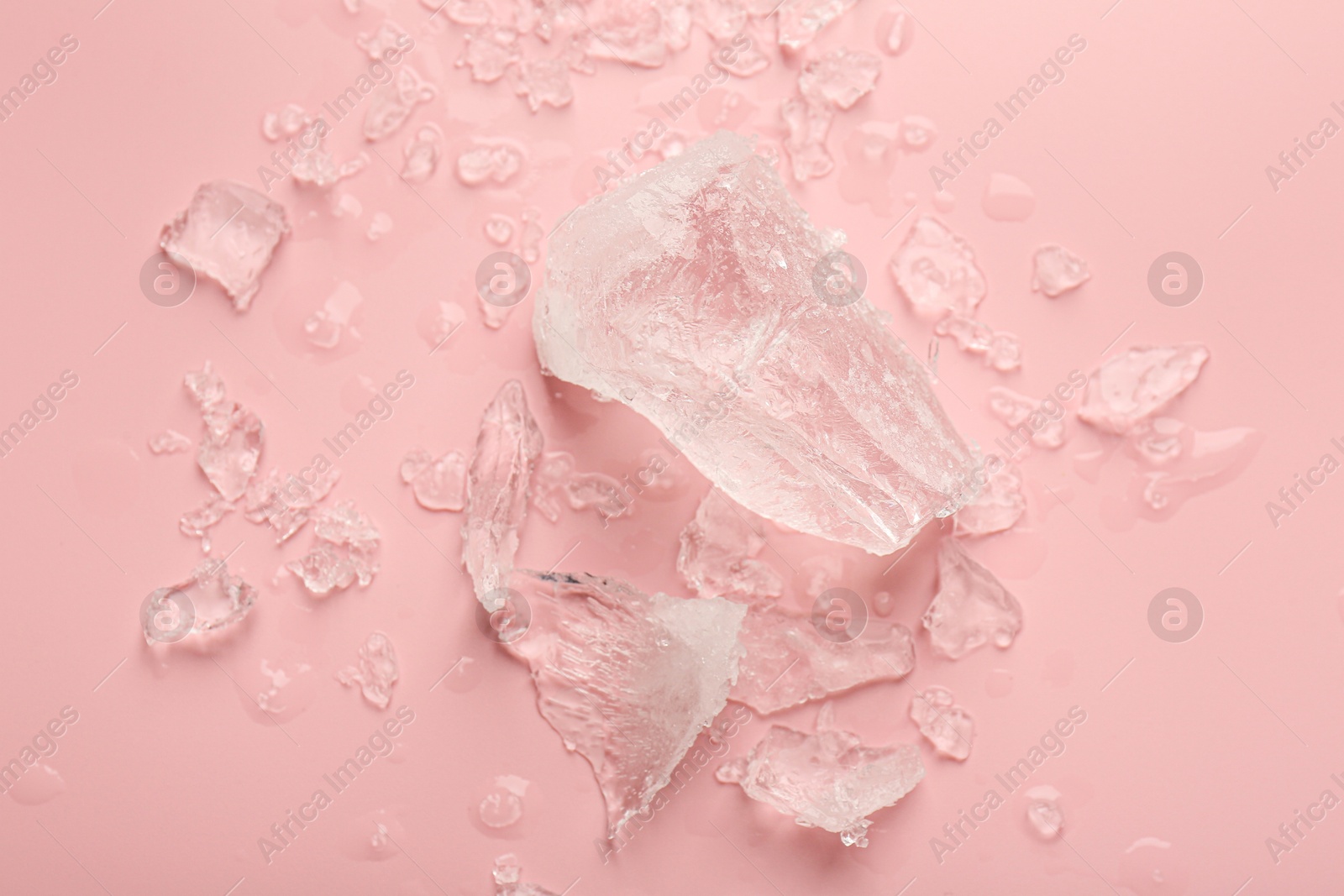 Photo of Pieces of crushed ice on pink background, top view