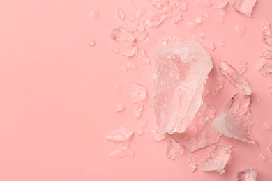 Photo of Pieces of crushed ice on pink background, top view. Space for text