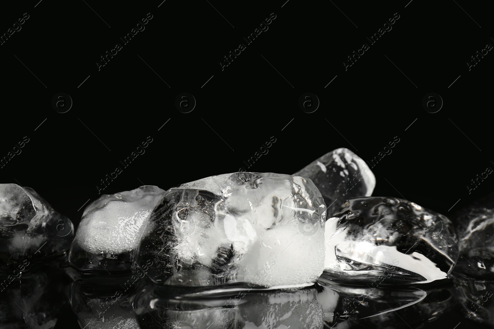 Photo of Pile of crushed ice on black mirror surface