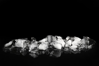 Photo of Pile of crushed ice on black mirror surface, space for text