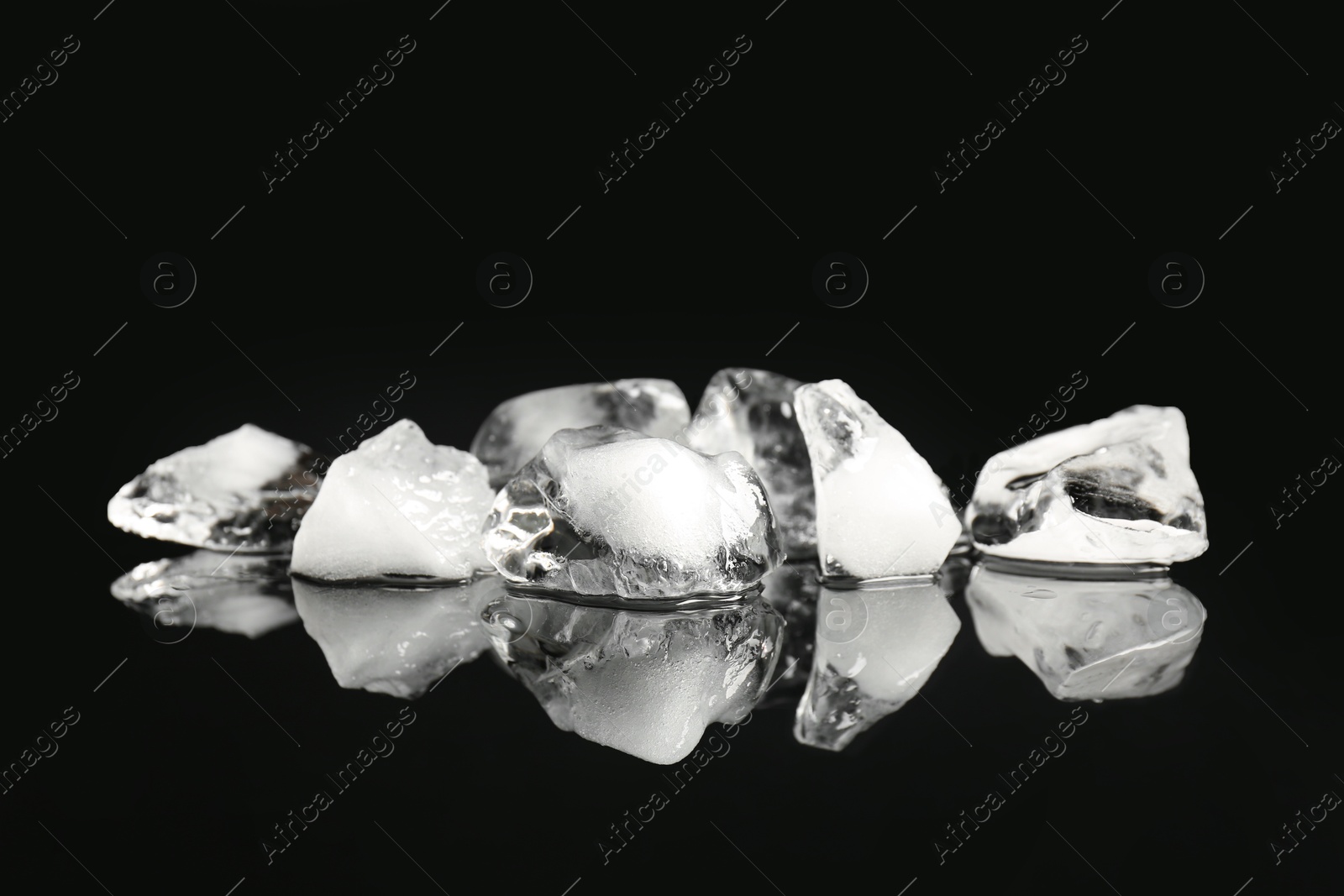 Photo of Pile of crushed ice on black mirror surface