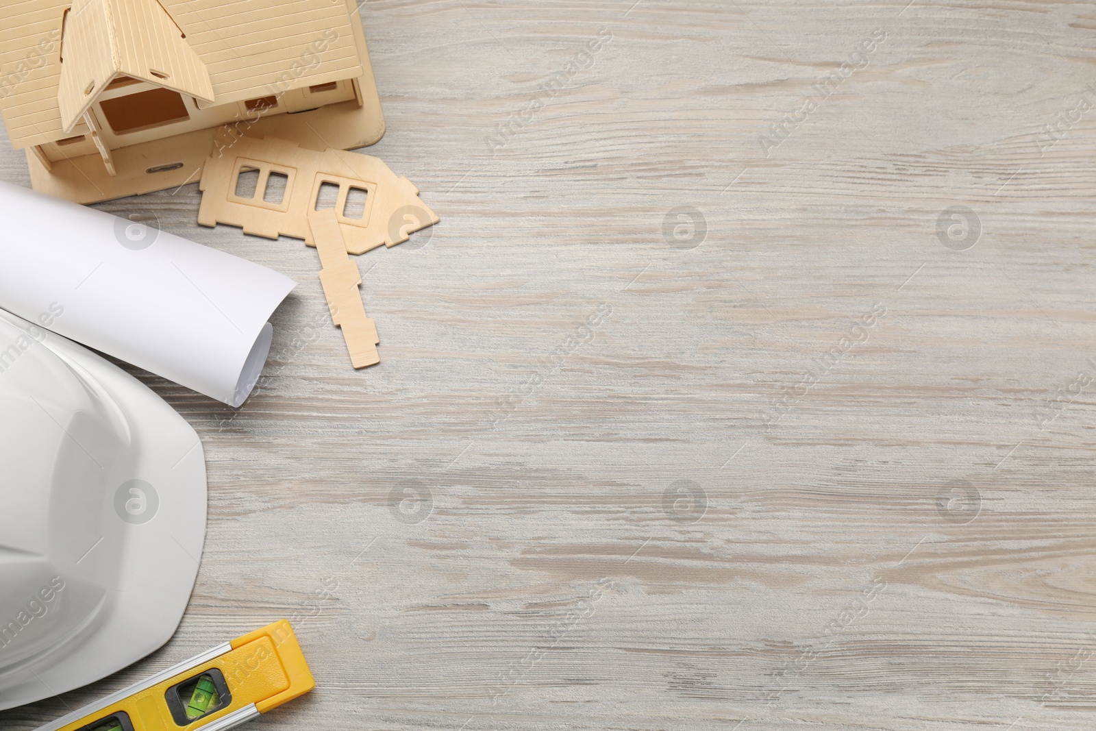 Photo of Flat lay composition with building level and other construction tools on white wooden table, space for text