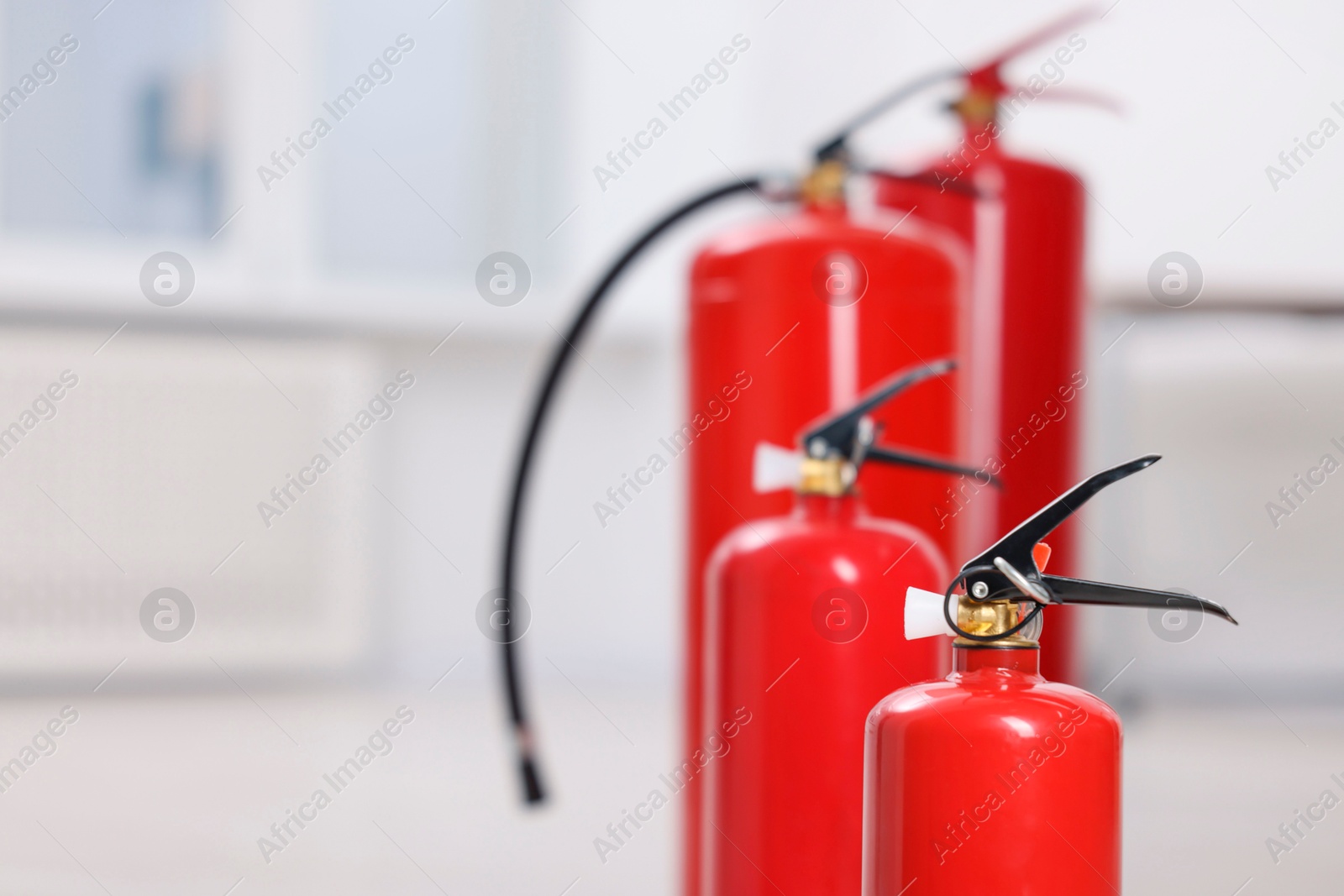 Photo of Fire extinguishers indoors, closeup. Space for text