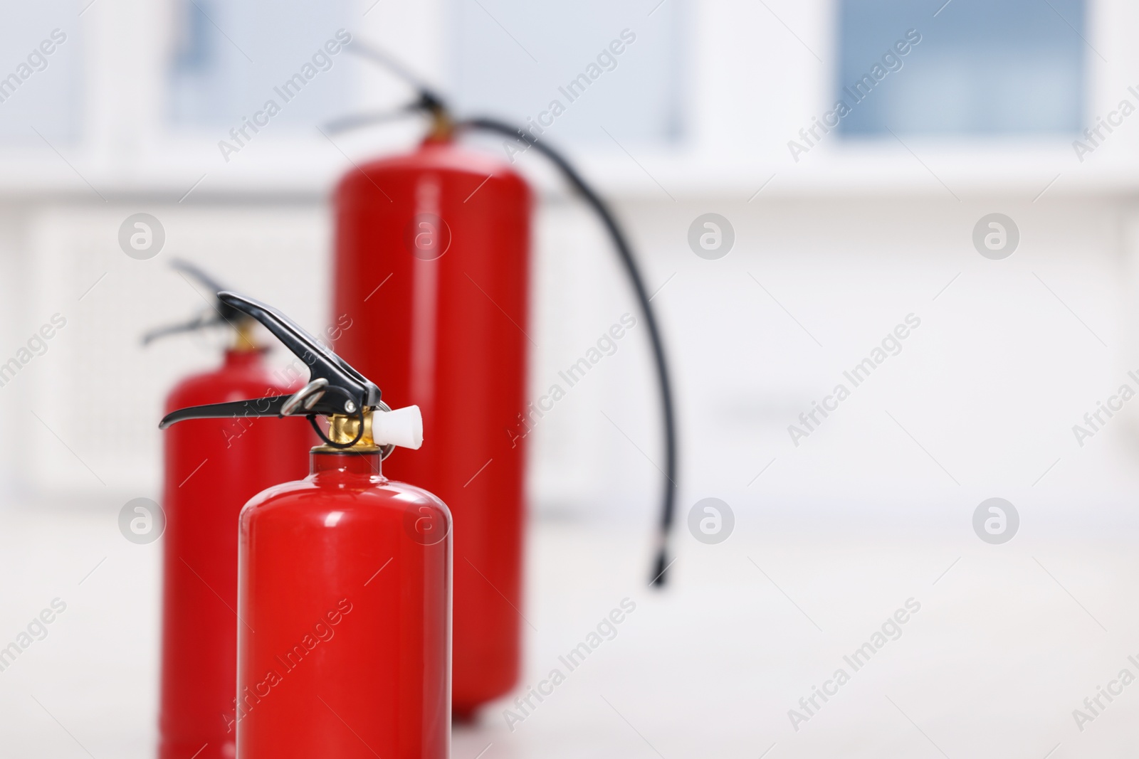 Photo of Fire extinguisher indoors, closeup. Space for text