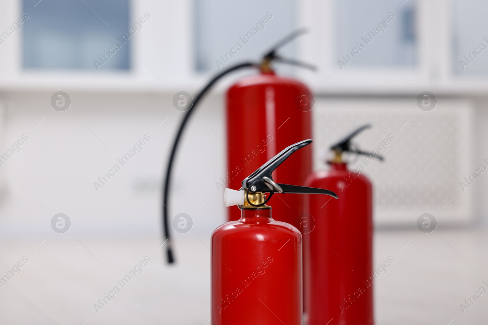 Photo of Fire extinguisher indoors, closeup view. Safety equipment