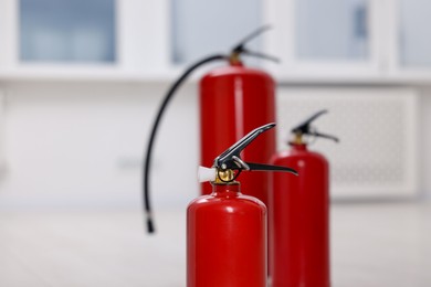 Photo of Fire extinguisher indoors, closeup view. Safety equipment