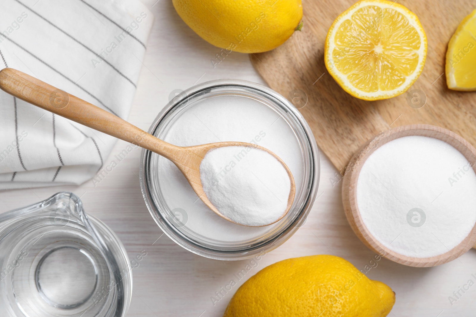 Photo of Baking soda, vinegar and lemons on white wooden table, flat lay