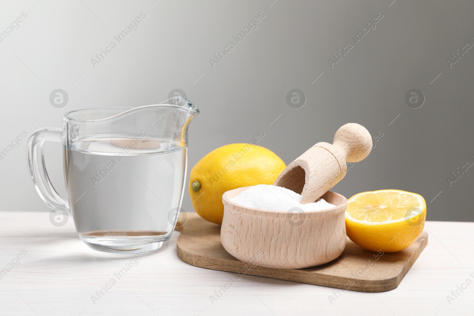 Photo of Baking soda, vinegar and lemons on white wooden table