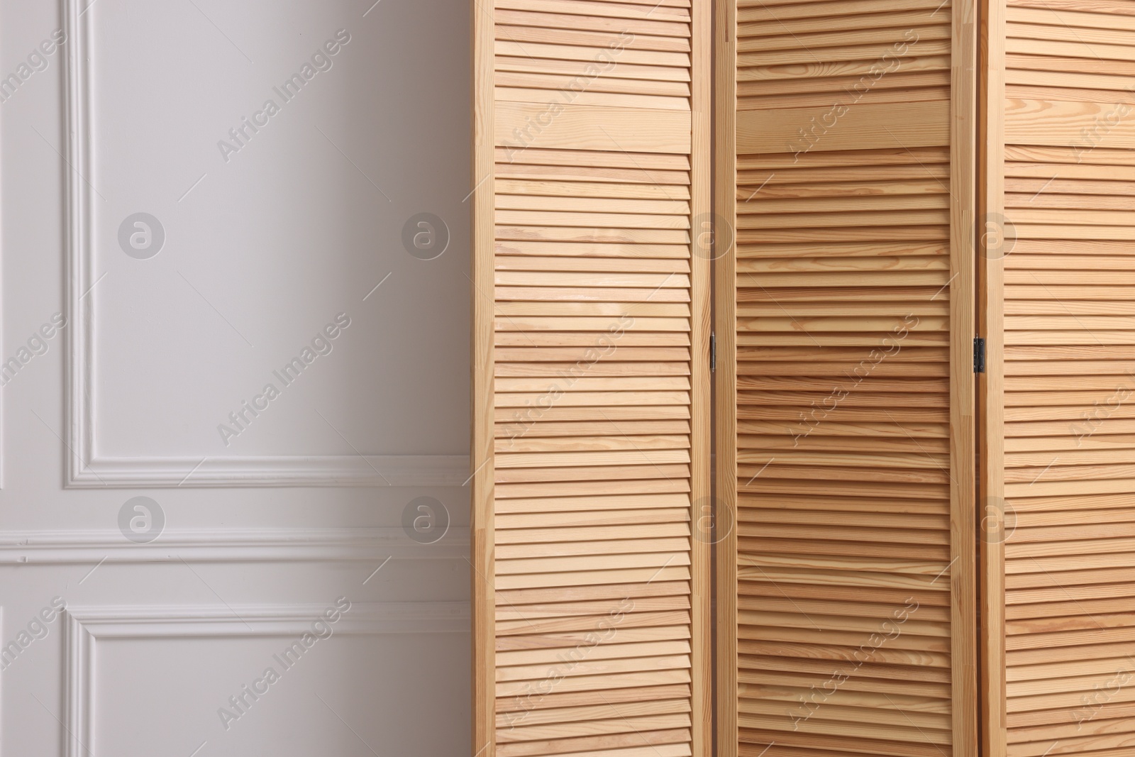 Photo of Folding screen near white wall indoors, space for text. Interior element