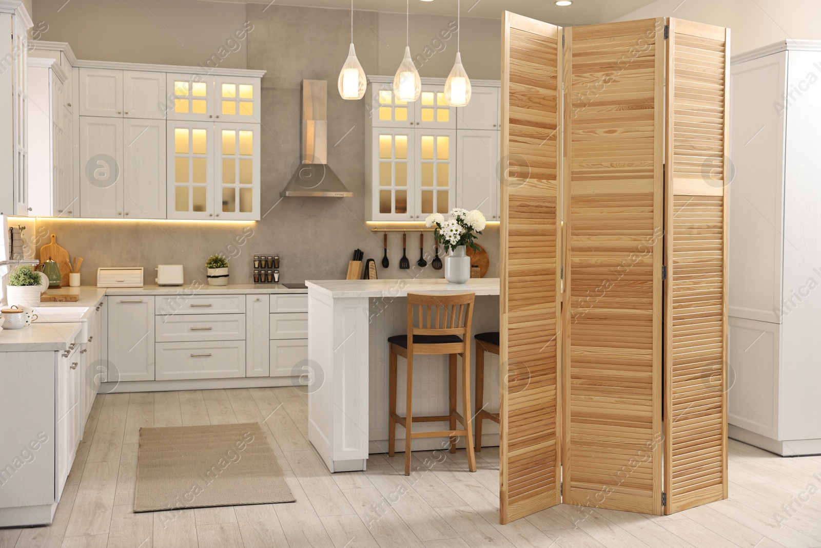 Photo of Stylish kitchen interior with folding screen and table