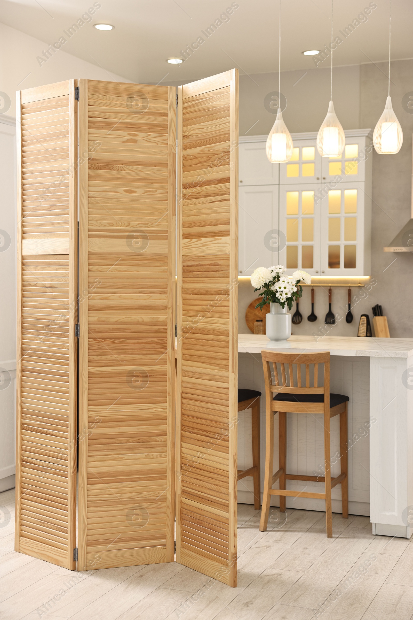 Photo of Stylish kitchen interior with folding screen and table