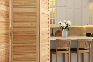 Photo of Stylish kitchen interior with folding screen and table