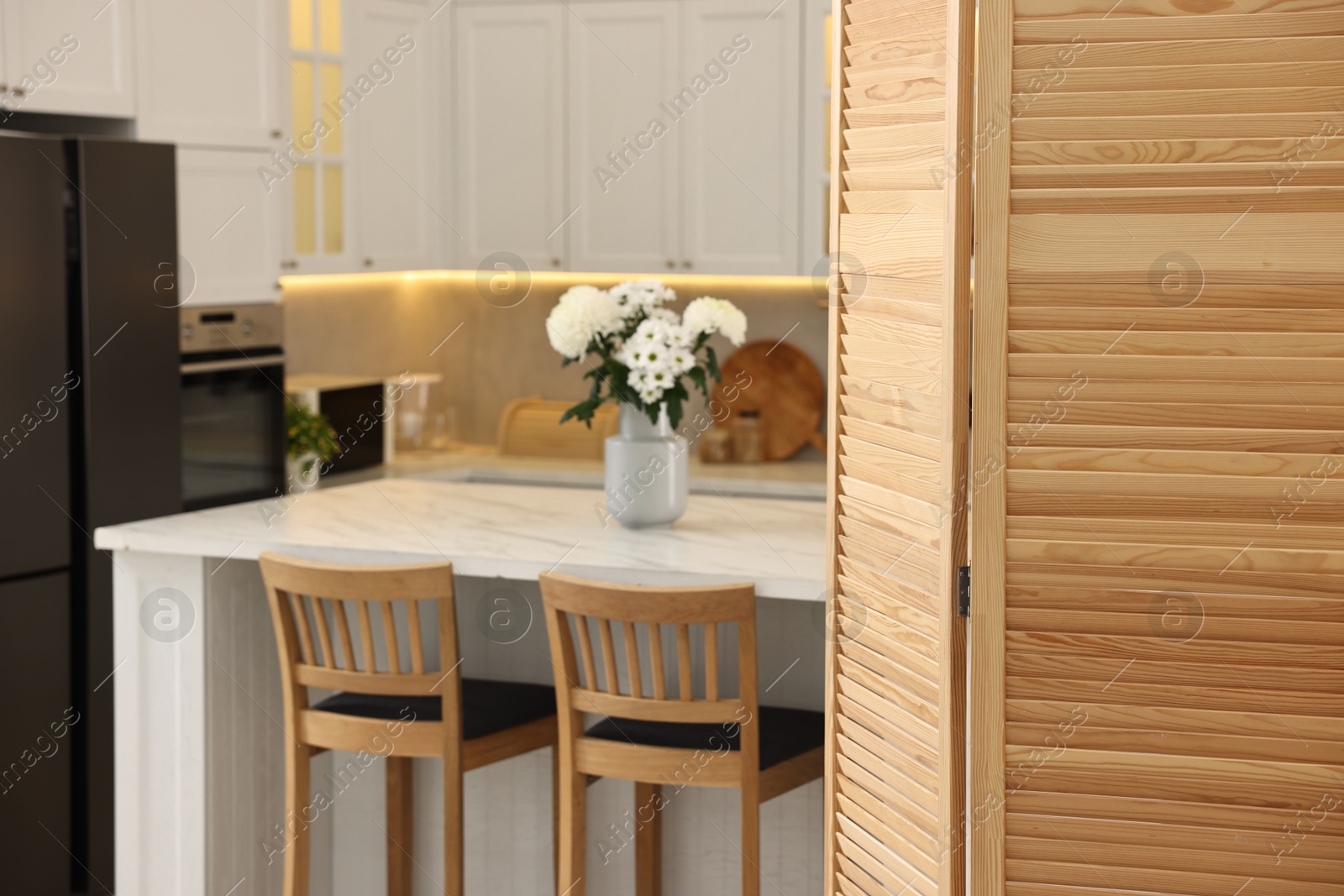 Photo of Stylish kitchen interior with folding screen and table