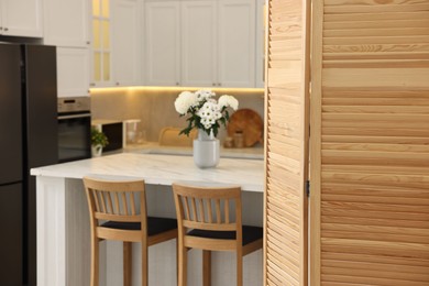 Stylish kitchen interior with folding screen and table