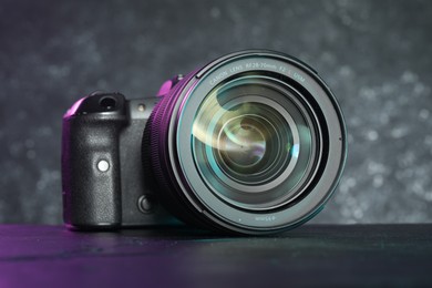 Modern photo camera on black table. Photographer's equipment