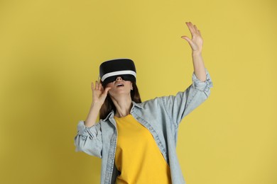 Woman using virtual reality headset on yellow background