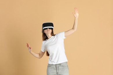 Woman using virtual reality headset on beige background