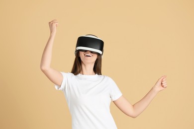 Photo of Smiling woman using virtual reality headset on beige background