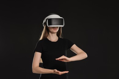 Woman using virtual reality headset on black background