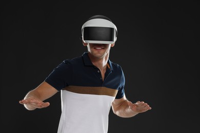 Photo of Man using virtual reality headset on black background