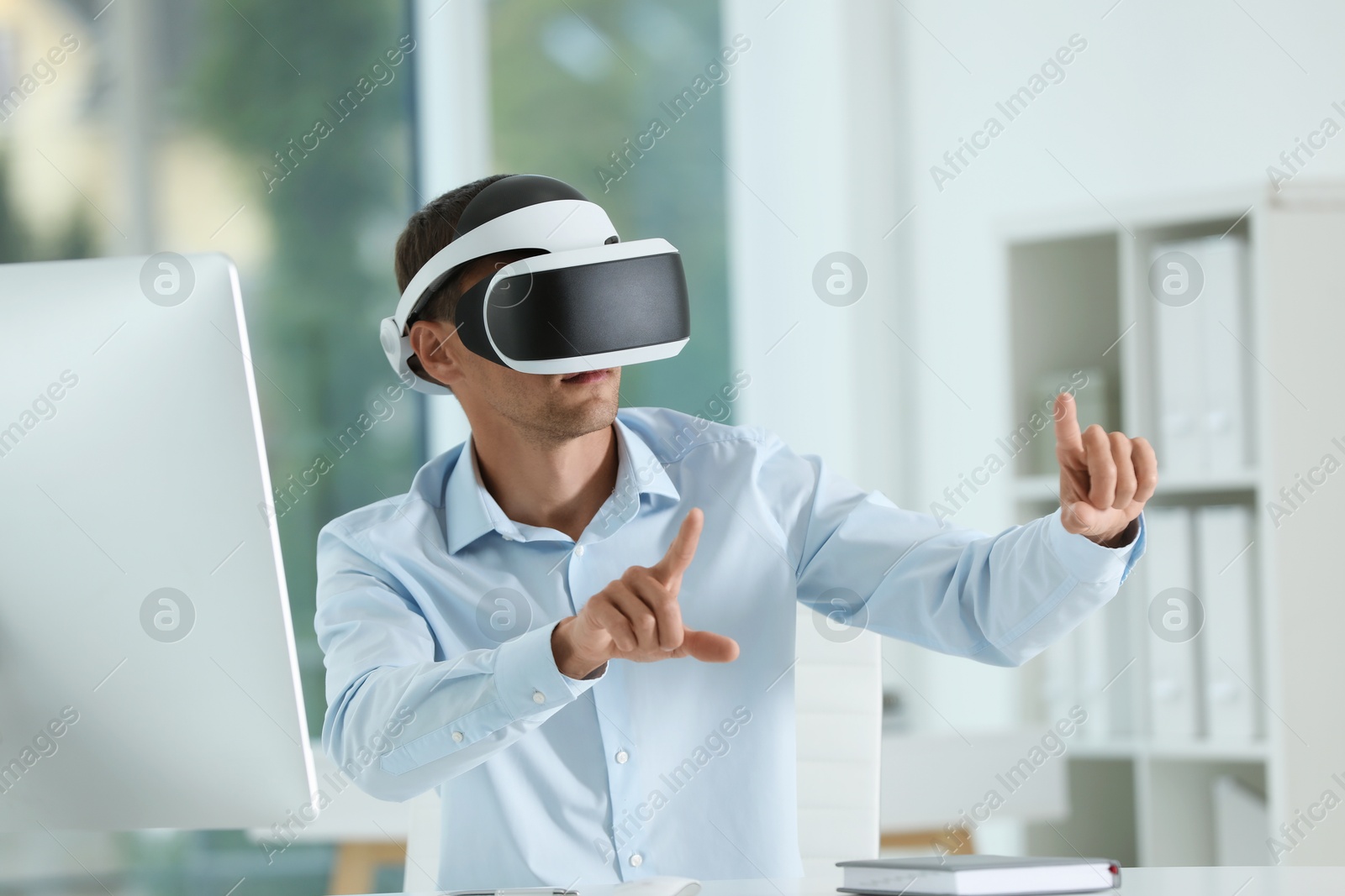 Photo of Man using virtual reality headset in office