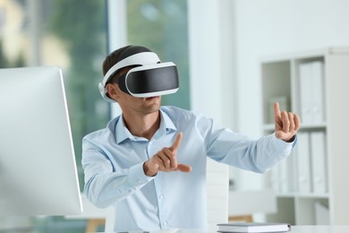 Photo of Man using virtual reality headset in office