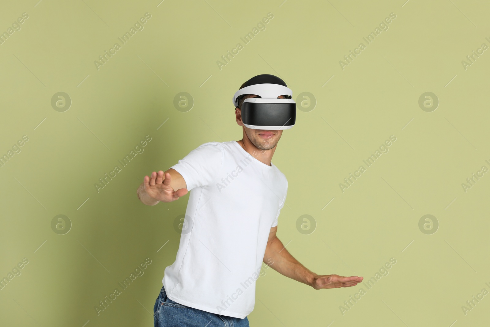 Photo of Man using virtual reality headset on light green background