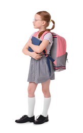 Cute little girl with books and backpack on white background