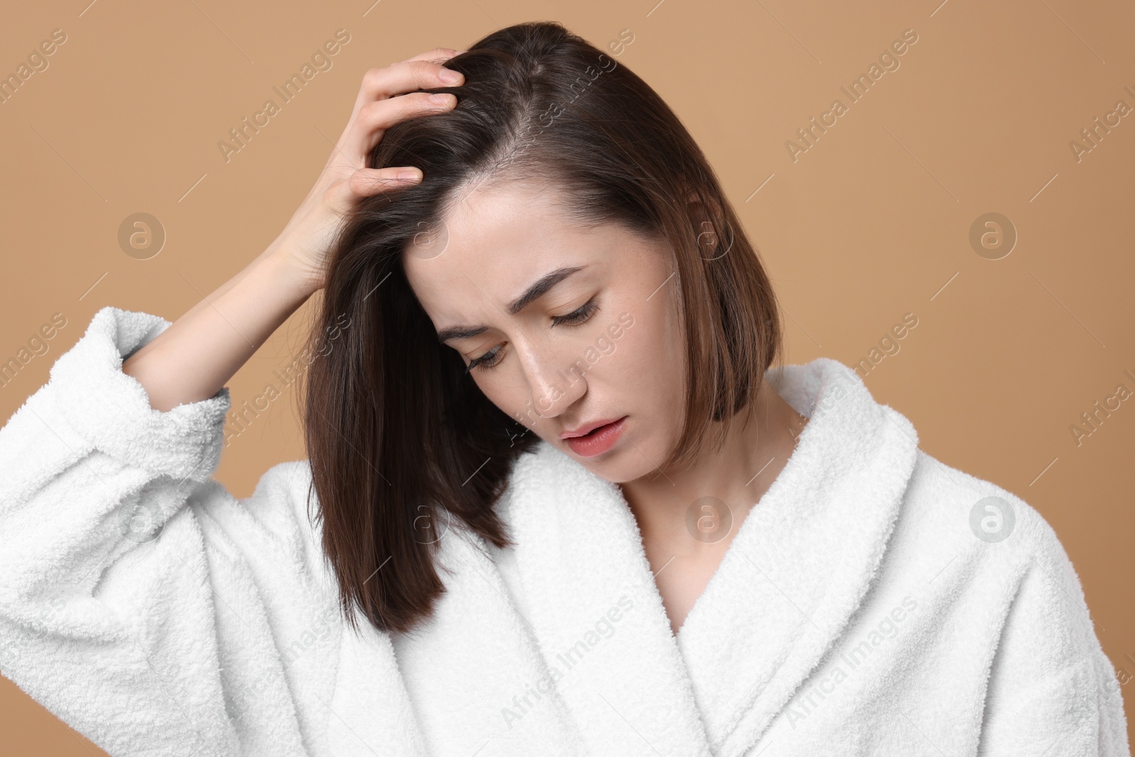 Photo of Sad woman with hair loss problem on light brown background