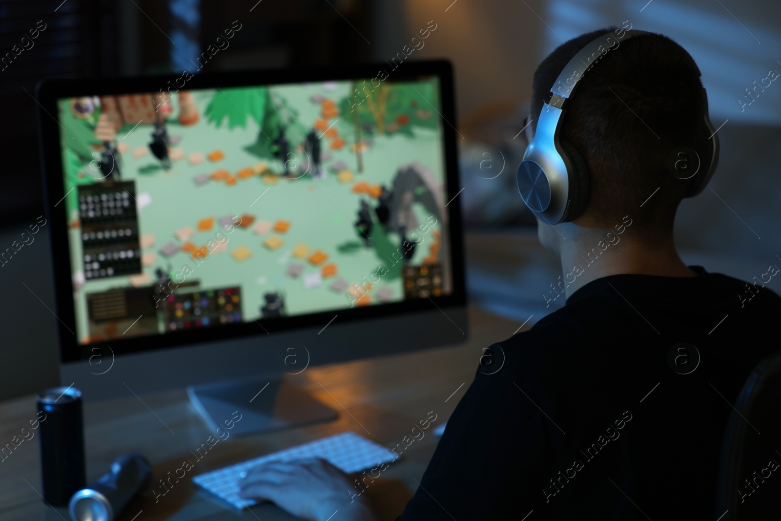 Photo of Man playing video games on computer at table indoors