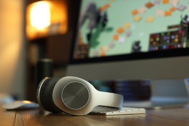 Photo of Headphones and computer on table indoors, selective focus