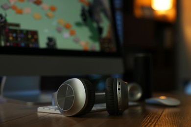 Photo of Headphones and computer on table indoors, selective focus